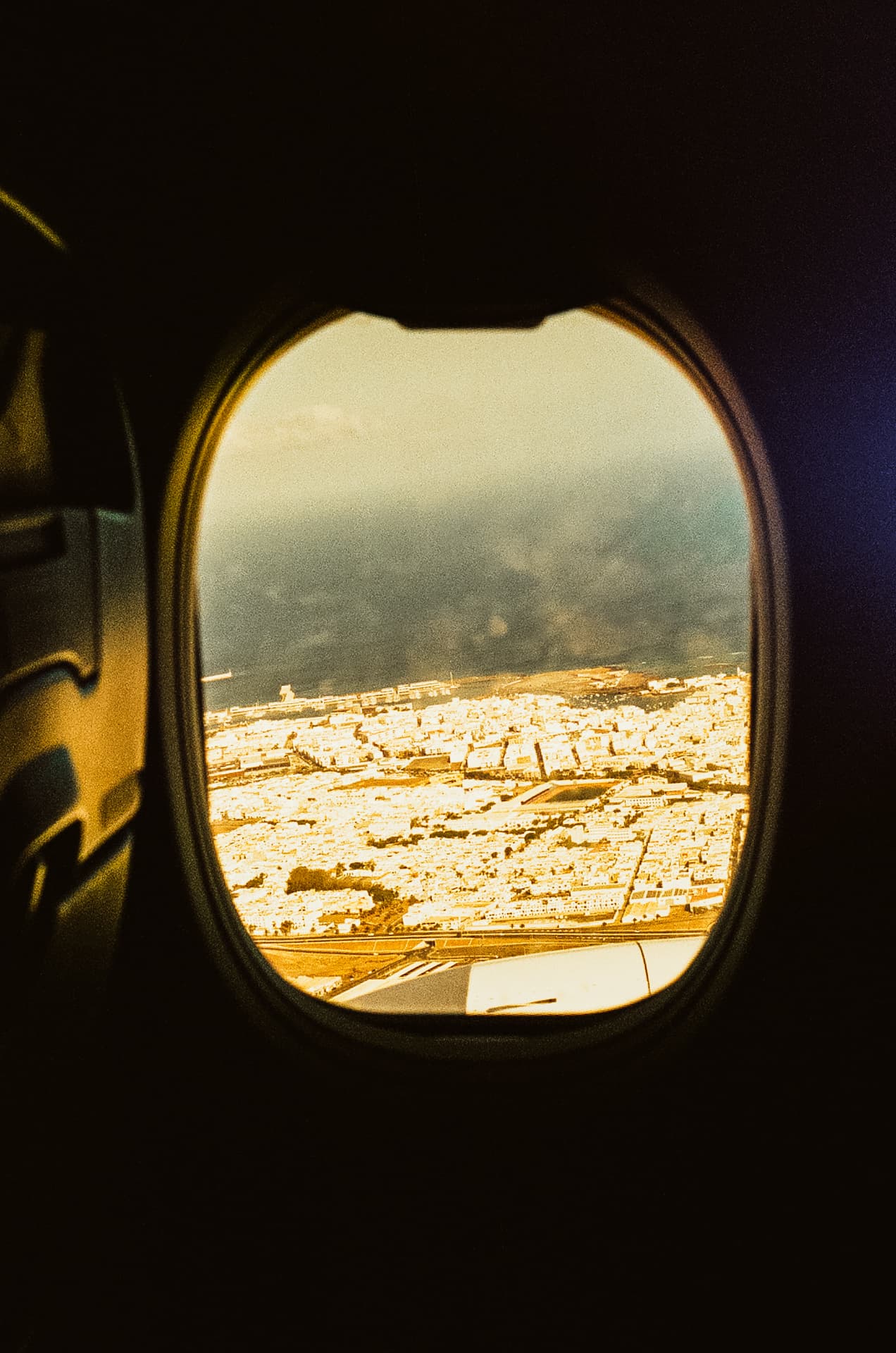 Sunlit city viewed through an airplane window
