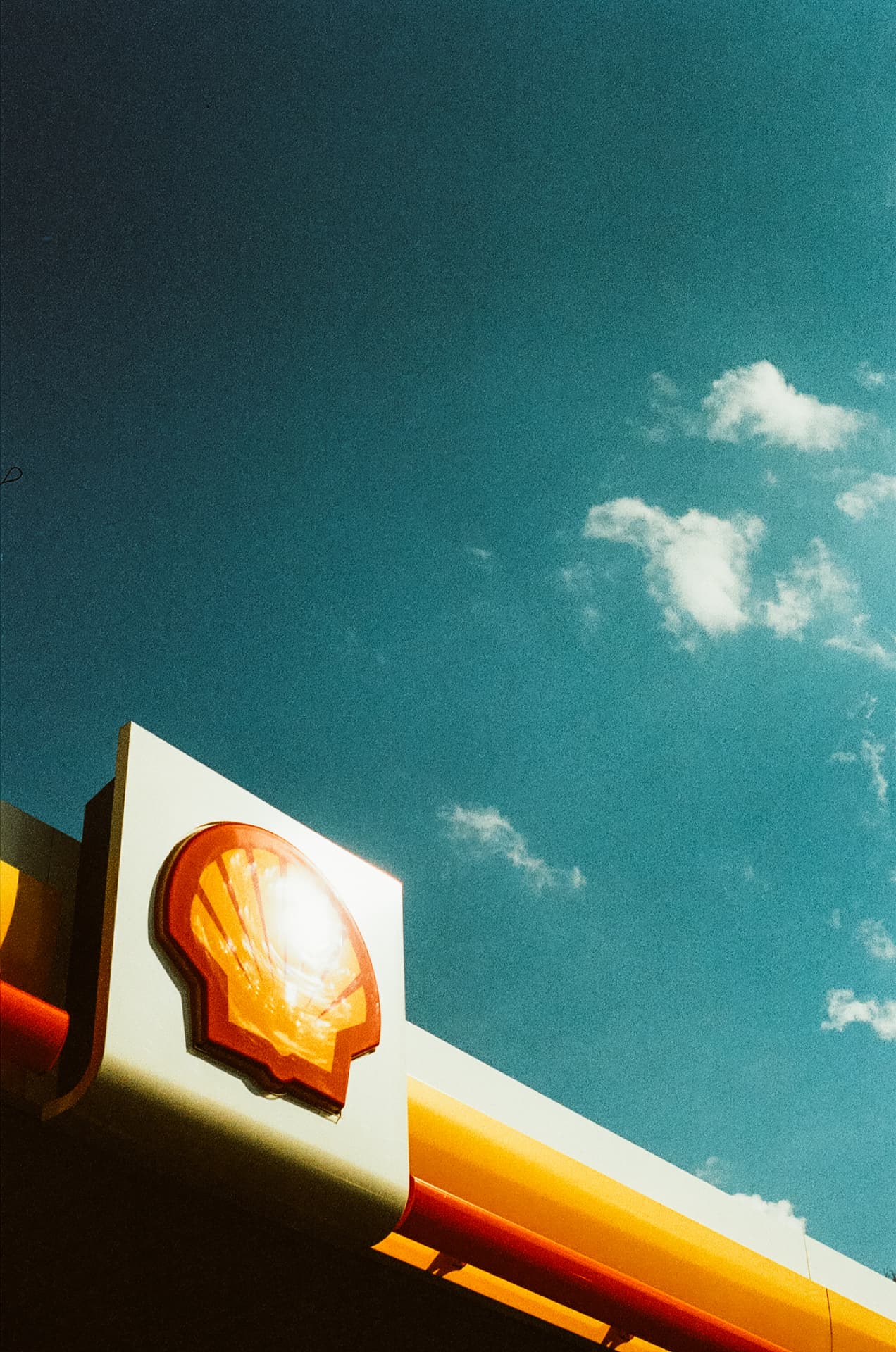 Shell sign against a bright blue sky