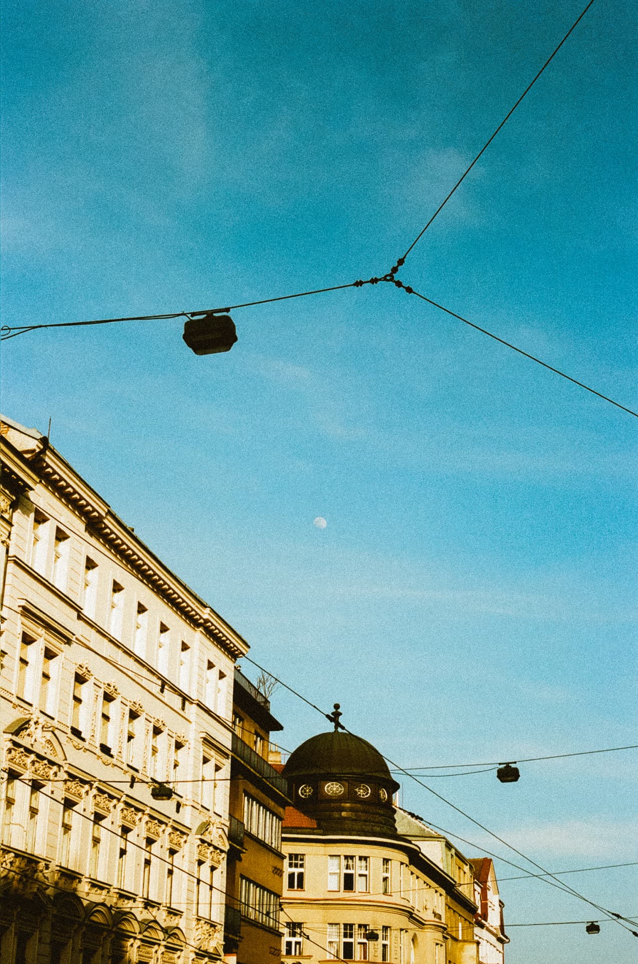 Prague architecture and tram wires against a blue sky