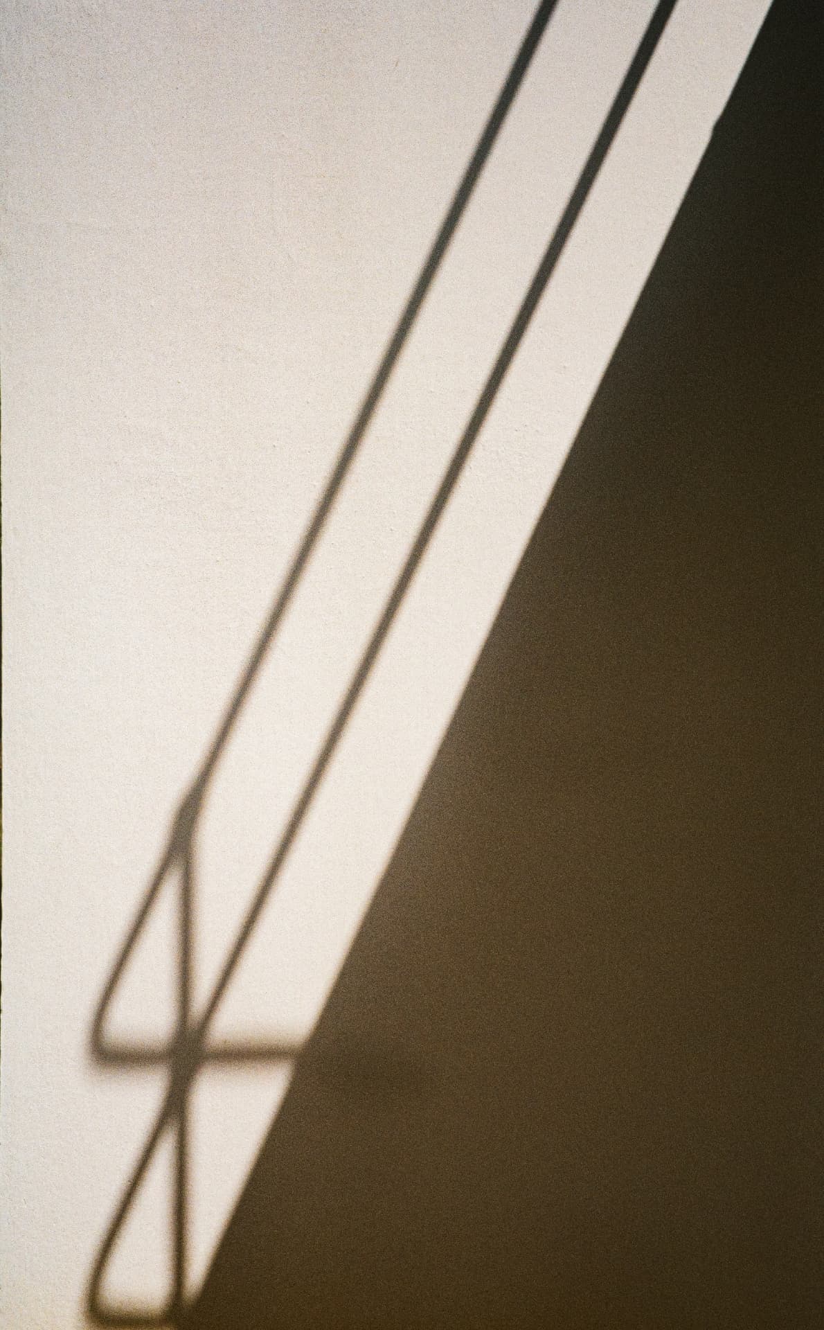 Abstract shadows cast across a pale wall