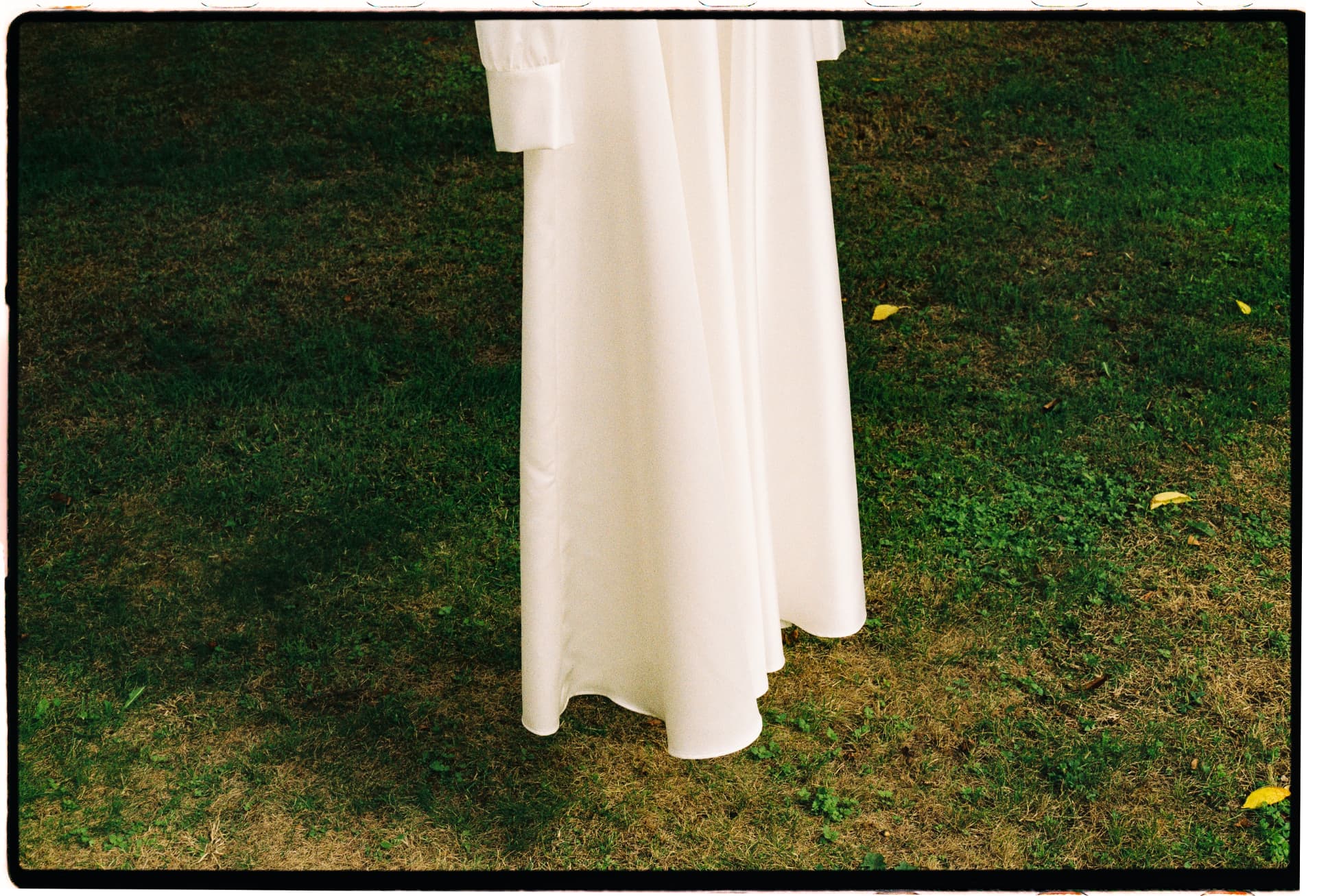 Wedding dress hanging over green grass